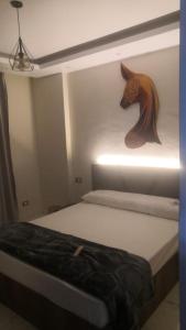 ‘Ezbet Abd el-Hâdi ‘AfîfiIsmailia的卧室配有一张带马头的墙壁床。
