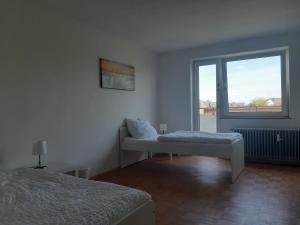 吕嫩Apartment mit Balkon in Lünen的白色的客房设有床和窗户。