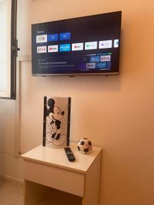RoccasicuraVico Gioia的墙上的电视机,桌子上放着一幅微球鼠标图
