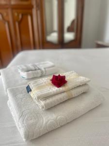 RoccasicuraVico Gioia的一堆毛巾,桌子上有一朵玫瑰