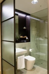 墨尔本考伯史密斯酒店的一间带卫生间和玻璃淋浴间的浴室