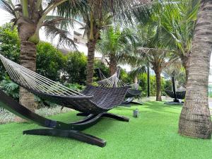 马六甲Bali Residence Melaka near Jonker Street的棕榈树公园内的两张吊床