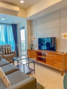 棉兰Brand new 2BR Empire Tower - Podomoro City的带沙发和电视的客厅