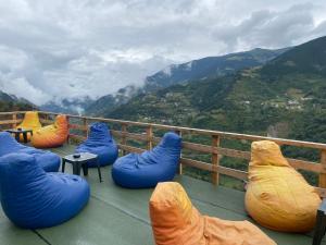 特拉布宗Yamaç Çam Hotel的阳台设有蓝色和橙色豆袋,享有山景