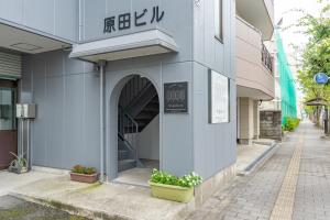 佐贺市佐賀インターナショナルゲストハウスHAGAKURE 2号店的人行道上花 ⁇ 的建筑物入口