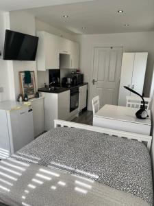 格拉斯哥Modern Comfy One Bed Apartment - Free Parking的厨房配有白色橱柜和黑白桌子。