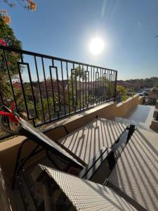 威廉斯塔德Cubana Resort Appartement loopafstand Mambo beach的阳台配有桌椅和围栏。