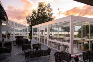 鲁森达尔罗森达尔弗奥德酒店的餐厅设有玻璃墙和桌椅