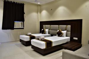 加雅Hotel Kusum Palace的一间带两张床和一张沙发的卧室
