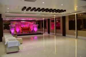 加雅Hotel Kusum Palace的大堂设有红色椅子和紫色照明