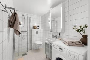 奥斯陆Unique Oslo/Vika Apartment的白色的浴室设有洗衣机和水槽。