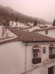 格拉茨莱马Hospederia Casa de las Piedras的一座白色的建筑,设有两扇窗户,享有山景