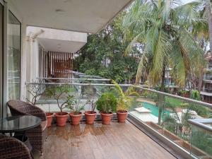 卡兰古特Goan Fiesta 1BHK Pool View at Eternal Wave CALANGUTE的一个带盆栽植物的阳台和一个游泳池