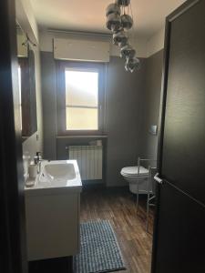 圣焦万尼泰亚蒂诺PennysHouse的一间带水槽和卫生间的浴室以及窗户。