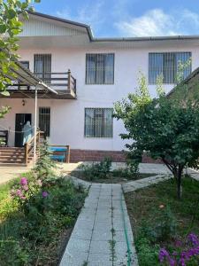 比什凯克Уютная вилла в центре Бишкека的前面有一条小路的白色房子