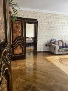 比什凯克Уютная вилла в центре Бишкека的客厅设有床铺和木地板
