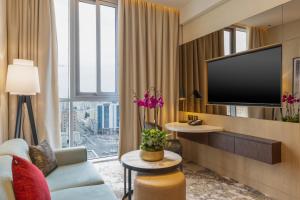 多哈Embassy Suites By Hilton Doha Old Town的一间带电视和沙发的客厅