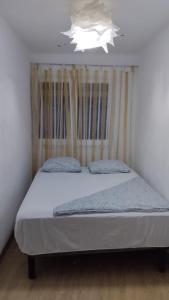 巴达洛纳metro La Salut的一张位于小客房内的床铺,拥有白色的天花板