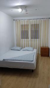 巴达洛纳metro La Salut的一间卧室配有一张床,铺有木地板