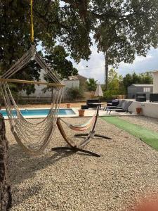 文蒂塞里Maison de vacances的悬在泳池旁树上的吊床