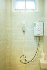 素可泰塔拉布里度假村幸福宿舍旅舍的带淋浴的浴室,浴室的软管与墙壁相连