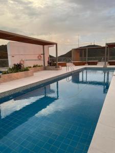 GairaApartasuite moderno y elegante en Playa Salguero的大楼前的蓝色海水游泳池