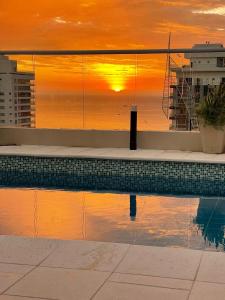 GairaApartasuite moderno y elegante en Playa Salguero的一座享有日落美景的游泳池