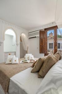 格拉纳达ADANAR-Apartamentos Muralla Zirí的一间卧室配有两张带枕头的床。