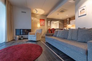 库雷萨雷HYGGE APART with fireplace at the seaside的客厅配有蓝色的沙发和红色地毯。