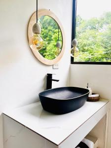 蓬塔雷纳斯Deluxe Loft 1 BDR con linda vista的浴室设有黑色浴缸,位于带镜子的柜台上