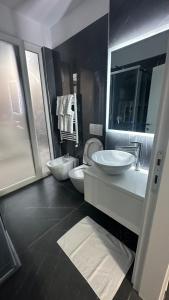 圣金Sole apartments的大型浴室设有两个盥洗盆和卫生间。