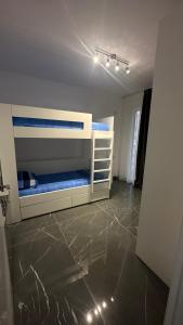 圣金Sole apartments的一间带两张双层床的卧室,铺有瓷砖地板。