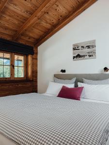 贝里斯泽尔Chalet Alpin mit privatem Whirlpool und Sauna的一间卧室配有一张带白色和紫色枕头的床