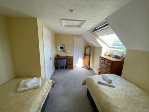 博利厄New Forest View的一间卧室设有两张床、一张桌子和一个窗口。