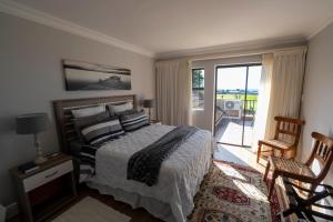 莫塞尔湾Fairways Apartment Mossel Bay Golf Estate的一间卧室设有一张床和一个阳台