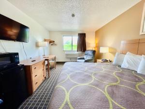 昆西The Quincy Inn & Suites的酒店客房设有一张大床和一张书桌。