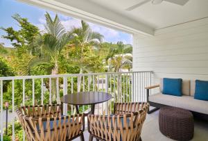 拿撒勒Morningstar Buoy Haus Beach Resort at Frenchman's Reef, Autograph Collection的阳台配有桌子、两把椅子和一张沙发。