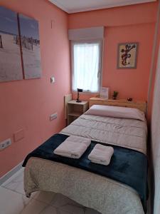 桑坦德Apartamento Zona Playa y centro Ciudad的一间卧室设有两张床和一个带毛巾的窗户。