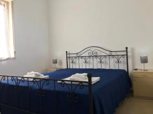 夏卡S.Giorgio Apartments的一间卧室配有蓝色的床、蓝色的床单和灯具