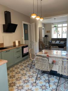 阿尔贝COTTAGE DU PARC的厨房以及带桌椅的起居室。