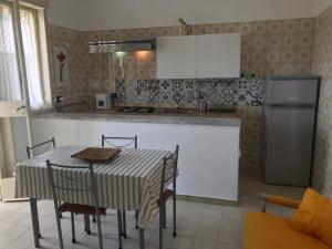 夏卡S.Giorgio Apartments的厨房配有桌椅和冰箱。
