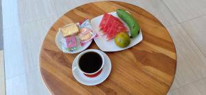 沙努尔欧文客房旅馆的餐桌,带两盘食物和一杯咖啡的桌子
