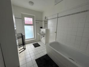 柏林Eastside 35的白色的浴室设有浴缸和水槽。