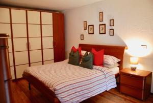 努斯Cà Mia的一间卧室配有红色和绿色枕头的床