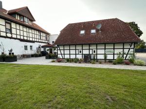 ZerbstPension Am Stadtrand Zerbst的两座黑白建筑,设有绿色草坪