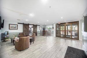 格兰德港Baymont by Wyndham Grand Haven的大型客厅铺有木地板,配有家具。