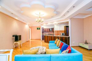 巴库Deluxe Apartment 142/43的一间带蓝色沙发的客厅和一间厨房