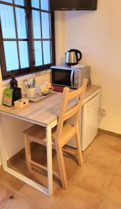 米尔芳提斯城Cantinho de Milfontes Jacuzzi的厨房配有桌椅和微波炉