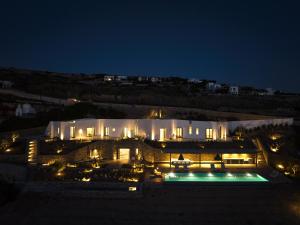 KrotiriOlithos Villas的一座大型建筑,晚上设有游泳池