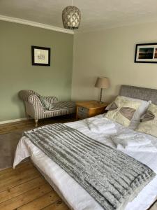 亚历山德里亚Loch Lomond Apartment的一间卧室配有一张大床和一把椅子